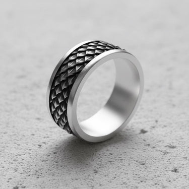 Silver Dragon Scale Ring for men, showing the oxidized scale pattern and polished edges, resting on a light grey concrete surface.