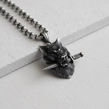 Front view of the handcrafted silver wolf pendant with a knife, highlighting the fierce expression and intricate fur texture.