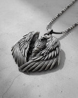 Angled view of the handcrafted silver eagle wings pendant, showcasing the three-dimensional depth and feather details.