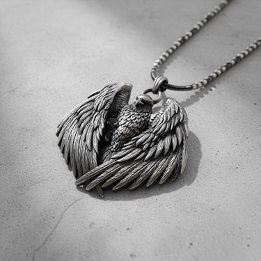 Angled view of the handcrafted silver eagle wings pendant, showcasing the three-dimensional depth and feather details.