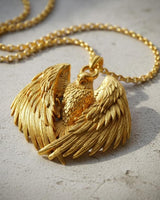 Front view of 14k gold vermeil eagle pendant with detailed spread wings on stone background