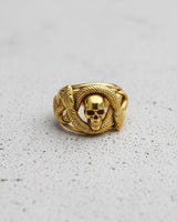 Front view of gold vermeil snake skull ring featuring double headed serpent wrapping around a skull on grey background