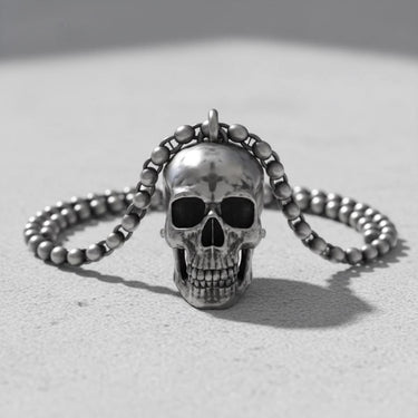 Artisan silver skull pendant with a bead chain, showcasing its oxidized details on a bright, textured surface.