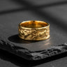 14K gold vermeil wolf ring featuring dynamic running wolves relief design displayed on textured black stone background