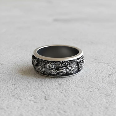 Side profile of the oxidized silver phoenix ring, displaying the continuous mythical bird design on a light gray stone.