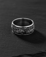 Silver Phoenix Ring with detailed Basan fire bird carving, shown from the front on a dark, textured slate surface.