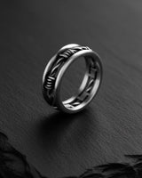 Close-up of the 925 sterling silver barbed wire ring, highlighting the oxidized finish and intricate details on a dark slate.