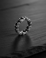 Handcrafted 925 silver bicycle chain ring for men, showcased on a dark slate background highlighting its metallic sheen.