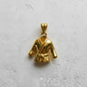 Gold vermeil judo gi pendant showing detailed knotted belt and lapels, displayed on a light, textured studio background.