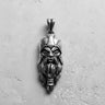 Silver Viking head pendant with an oxidized finish, showcasing the warrior's detailed face and helmet on a grey surface.