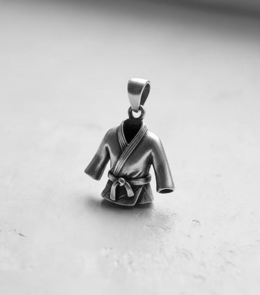 925 sterling silver martial arts gi pendant in an angled side view, shot in black and white to highlight the polished finish.