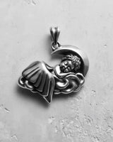 Oxidized 925 sterling silver sleeping angel pendant showing a detailed cherub on a cloud with a crescent moon background.