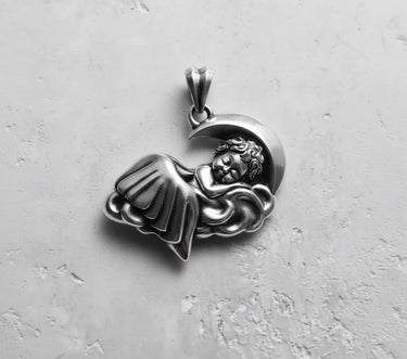 Oxidized 925 sterling silver sleeping angel pendant showing a detailed cherub on a cloud with a crescent moon background.