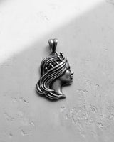 Handcrafted Silver Queen Pendant with dramatic lighting, showcasing the depth of the carving and oxidized details on the hair.