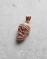 Rose gold bearded skull pendant with a warm metallic finish, highlighting the artisan details of the Memento Mori jewelry.