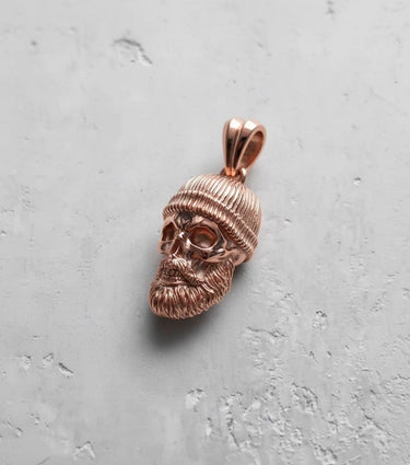 Rose gold bearded skull pendant with a warm metallic finish, highlighting the artisan details of the Memento Mori jewelry.