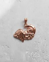 Rose gold sleeping angel pendant with a smooth, warm finish, displayed on a light background to showcase its delicate form.