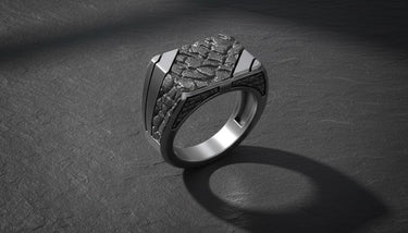 Angled view of the 925 silver nugget signet ring, highlighting the square face and the play of light on its rugged texture.