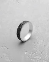 Silver moon ring with oxidized crater texture, showing the contrast with its polished sterling silver interior and edges.