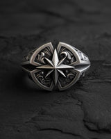 Silver Compass Ring featuring a central North Star design with detailed engravings, displayed on a dark, textured slate background.