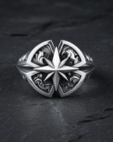Men's sterling silver compass ring with an oxidized finish highlighting the detailed North Star and side engravings on a dark surface.
