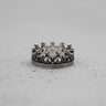 925 sterling silver crown ring with an oxidized finish and fleur-de-lis details, shown on a light grey textured surface.