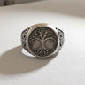 Front view of the Silver Yggdrasil Ring showcasing the intricate Tree of Life design on its face, set on a white surface.