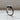 Handmade sterling silver Ouroboros ring resting on a white wooden ledge, highlighting the oxidized finish in natural light.