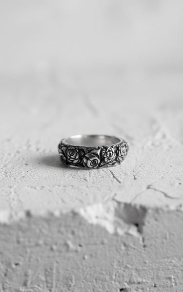Black and white photo of the sterling silver rose ring, highlighting the oxidized finish and deep petal details on a white surface.