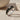 Close-up of handcrafted sterling silver snake ring resting on a textured stone highlighting the carved snake head.