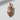 Close-up of luxury stylized owl pendant in rose gold plating with artistic shadows emphasizing the pointed body shape