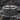 Close-up of handcrafted sterling silver band featuring deep oxidized scrollwork resting on a textured dark stone.