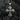 Gold tone gothic cross pendant with detailed relief work displayed on textured black surface