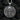 Silver skull and guns medallion necklace with oxidized finish showing depth and texture on rustic wooden surface