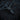 Angled view of handcrafted gothic skull pendant with black rhodium finish on textured wood surface