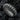 Close-up of the handcrafted corrugated band ring resting on dark stone, emphasizing the dark oxidized silver finish