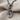 Close-up macro view of the sterling silver treble clef pendant resting on textured linen showing metal details