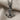 Close-up of handcrafted nautical anchor pendant resting on textured beige fabric highlighting metalwork