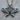 Close-up view of handcrafted oxidized silver butterfly pendant resting flat on a textured wooden surface background.