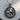 Close-up of handcrafted Saint George pendant resting on a natural wooden slice, highlighting the rich oxidized finish