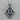 Close-up of the Gothic Thirteen Pendant resting on a wooden surface highlighting the vintage scrollwork
