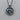 Close-up of the handcrafted Aquarius pendant resting on a textured wooden surface highlighting silver details.