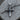 Close-up of rustic handcrafted 925 sterling silver nail cross pendant resting naturally on weathered wood