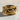 Close-up of the Pisces zodiac ring resting on a textured stone surface emphasizing the intricate fish scales