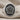 Close-up of oxidized sterling silver rose signet ring with gold petal detail displayed on beige linen fabric