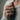 Woman wearing two-tone silver rose signet ring with gold accent on finger with cream sweater background