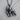 Close up of silver gorilla pendant featuring angry roaring face and muscular build on dark textured wood surface