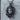 Coiled Serpent Medusa Pendant, oxidized, front view against stone backdrop