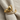 Close-up of the handcrafted baby foot ring on textured fabric highlighting the smooth gold vermeil finish and diamond accents