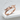 Spread Wings Ring, rose gold, angled view resting on stone ledge